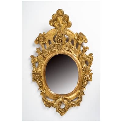 Miroir à fronton de forme ovale en bois sculpté et doré Italie XVIIIème siècle
