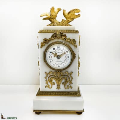 Gilt bronze clock on white marble base with couple of doves signed H. Renard, top. 25.5cm (End XIXe)