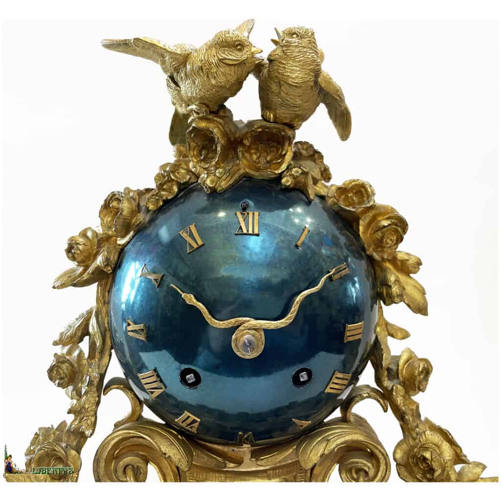 Pendule en bronze doré et métal bleu métallisé à décor de fleurs et couple de tourterelles, haut. 32 cm, avec deux candélabres à trois bras de lumière, haut. 40 cm, (Fin XIXe) 4