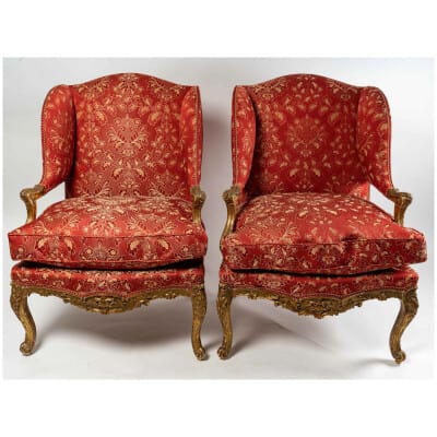Paire d’importants fauteuils à oreilles de style Louis XIV en bois sculpté et doré vers 1850