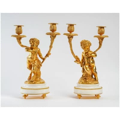 Paire de chandeliers de style Louis XVI en bronze doré Un Amour et Un Faune d’après Clodion et Delarue