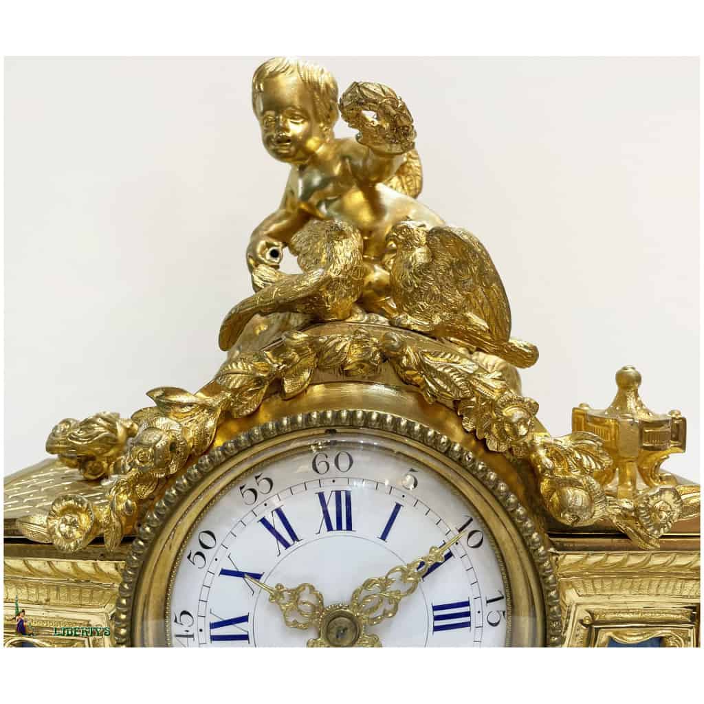 Pendule en bronze doré au mercure au décor de Cupidon avec deux tourterelles, avec plaques de porcelaine, mouvement avec suspension à fil de soie, haut. 28 cm, sur base bois doré, (Mi. XIXe) 4