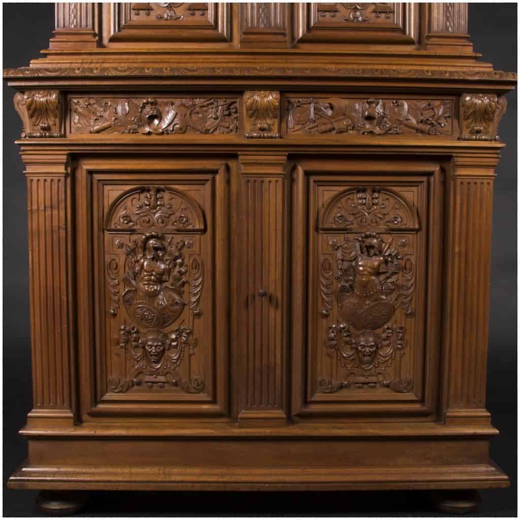 Buffet two bodies with the attributes of the war in carved walnut, XIXand 9