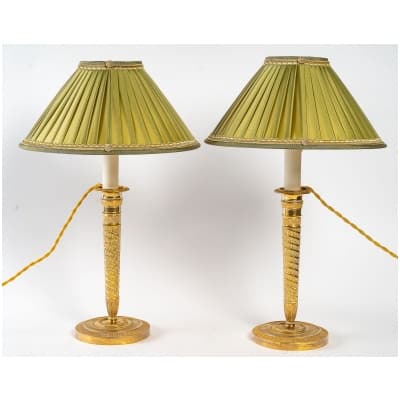 Paire de bougeoirs montés en lampes en bronze ciselé doré à décor de Rais de Cœurs d’époque Directoire vers 1798