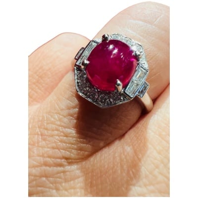 18 Carat Gold Ring Set With A Ruby Cabochon Surrounded By Diamonds