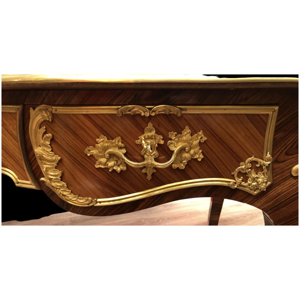 Louis XV style flat desk in rosewood and violet wood veneer, opening with three belt drawers and resting on arched legs. 9