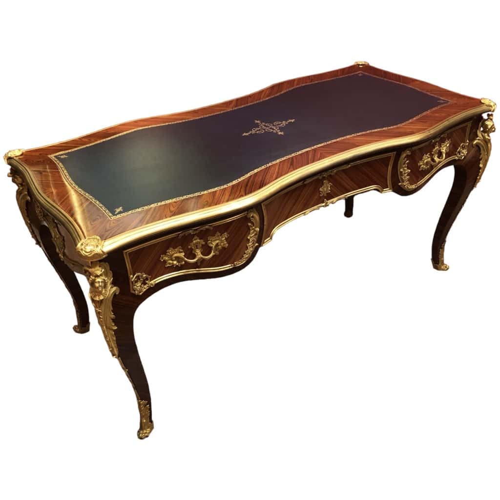 Louis XV style flat desk in rosewood and violet wood veneer, opening with three belt drawers and resting on arched legs. 10