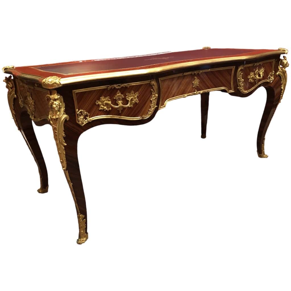 Louis XV style flat desk in rosewood and violet wood veneer, opening with three belt drawers and resting on arched legs. 11