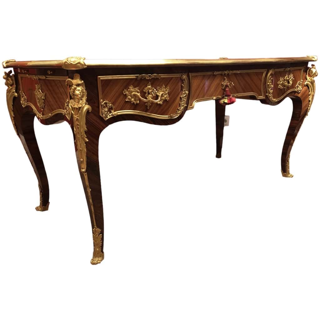 Louis XV style flat desk in rosewood and violet wood veneer, opening with three belt drawers and resting on arched legs. 3