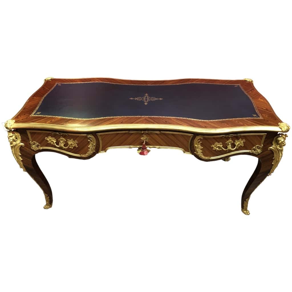 Louis XV style flat desk in rosewood and violet wood veneer, opening with three belt drawers and resting on arched legs. 7