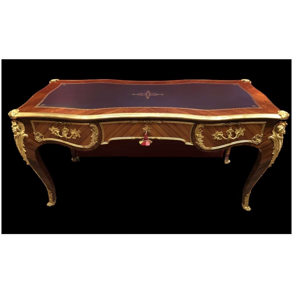 Bureau plat de style Louis XV en placage de bois de rose et bois de violette, ouvrant par trois tiroirs en ceinture et reposant sur des pieds cambrés. 6