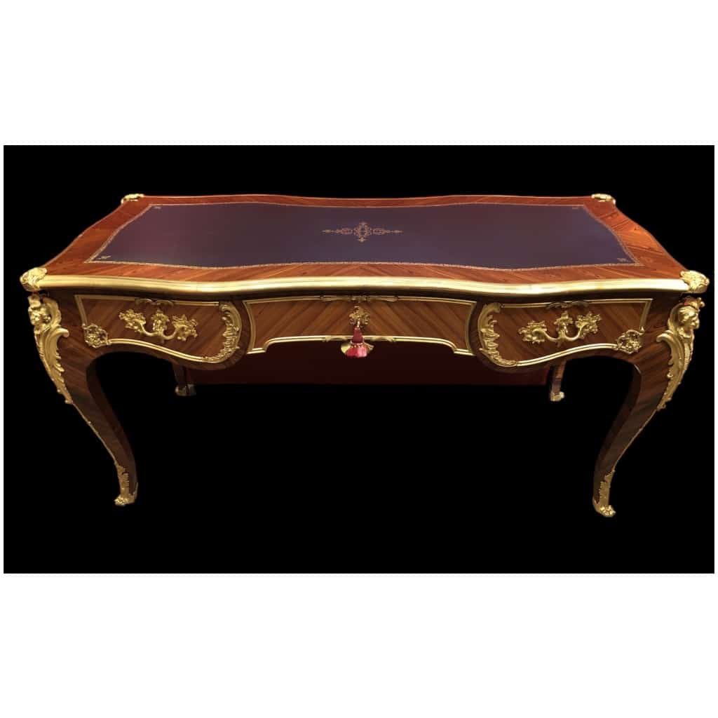 Louis XV style flat desk in rosewood and violet wood veneer, opening with three belt drawers and resting on arched legs. 6