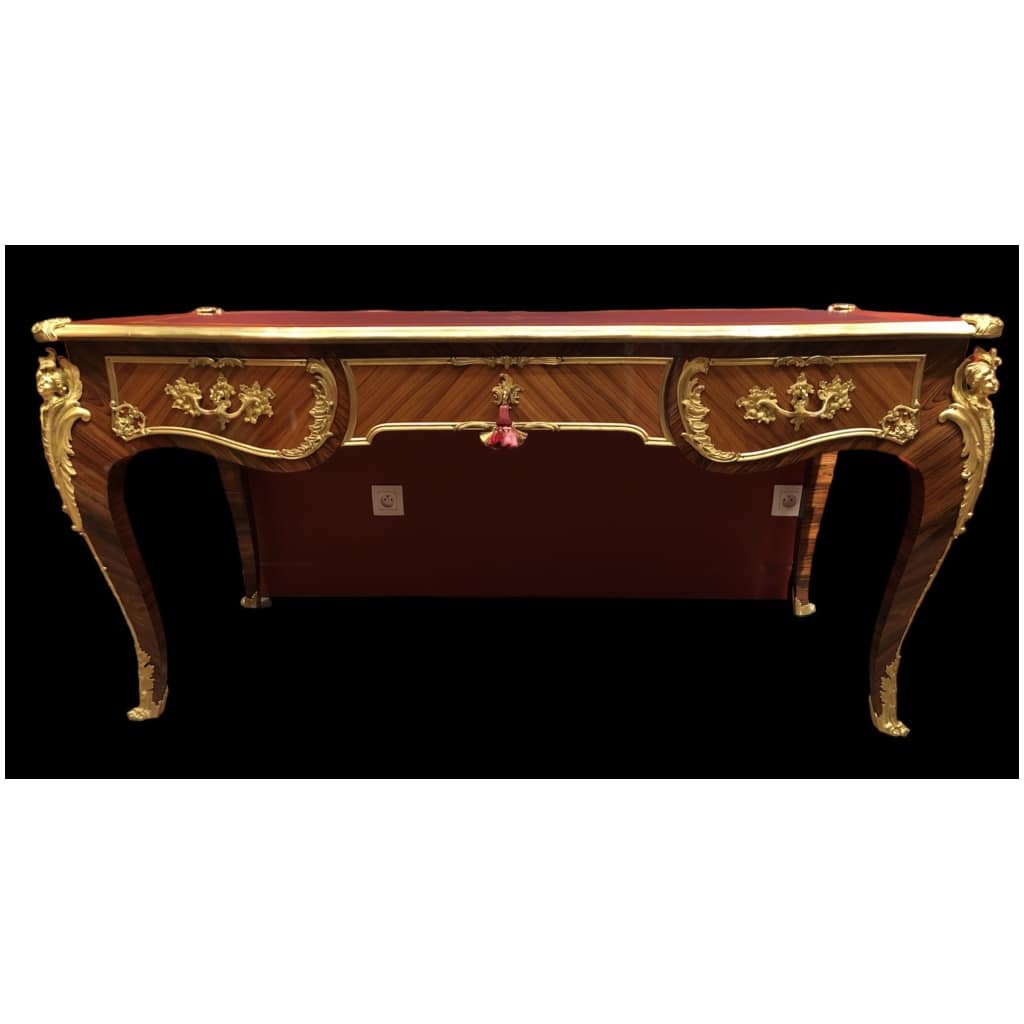 Louis XV style flat desk in rosewood and violet wood veneer, opening with three belt drawers and resting on arched legs. 5