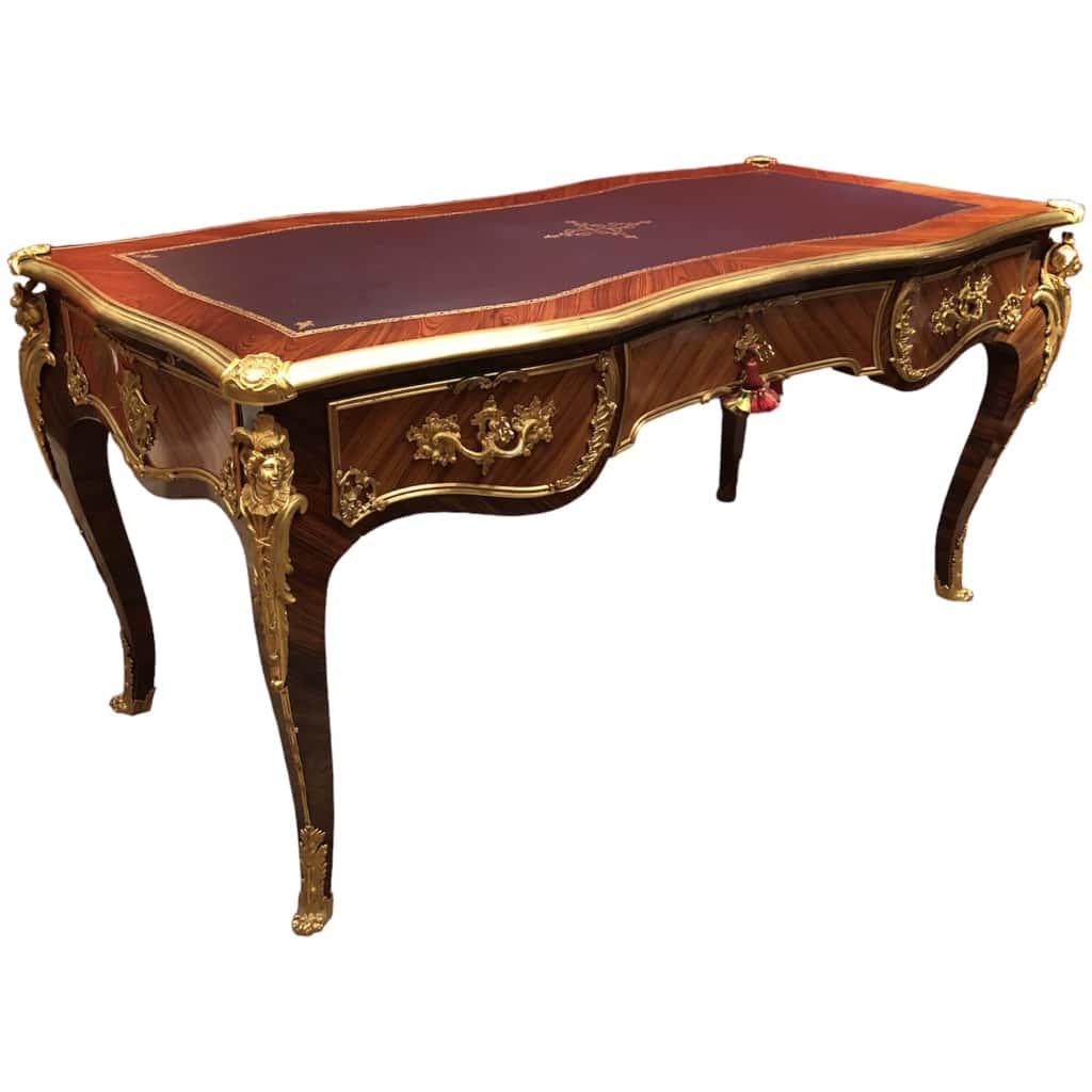 Louis XV style flat desk in rosewood and violet wood veneer, opening with three belt drawers and resting on arched legs. 4