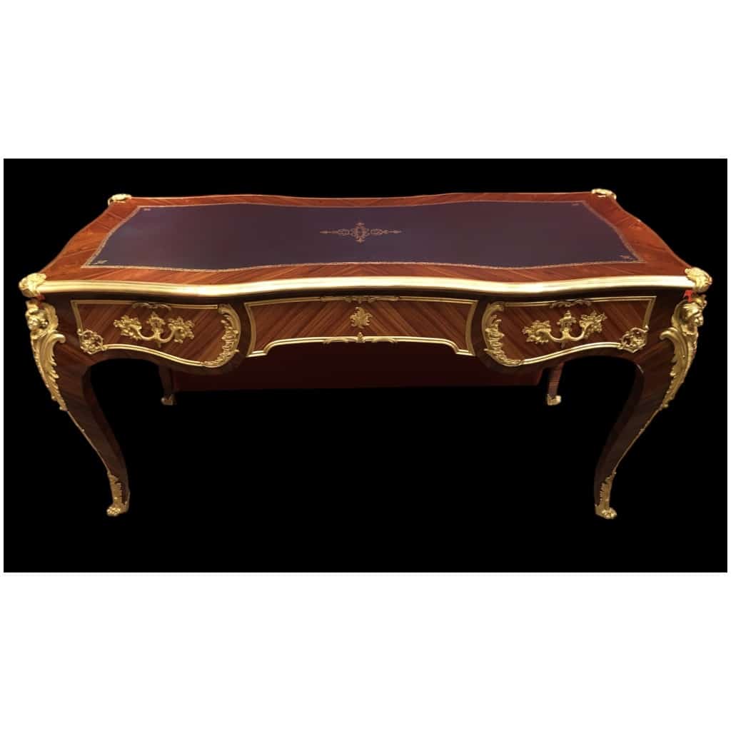 Bureau plat de style Louis XV en placage de bois de rose et bois de violette, ouvrant par trois tiroirs en ceinture et reposant sur des pieds cambrés. 17