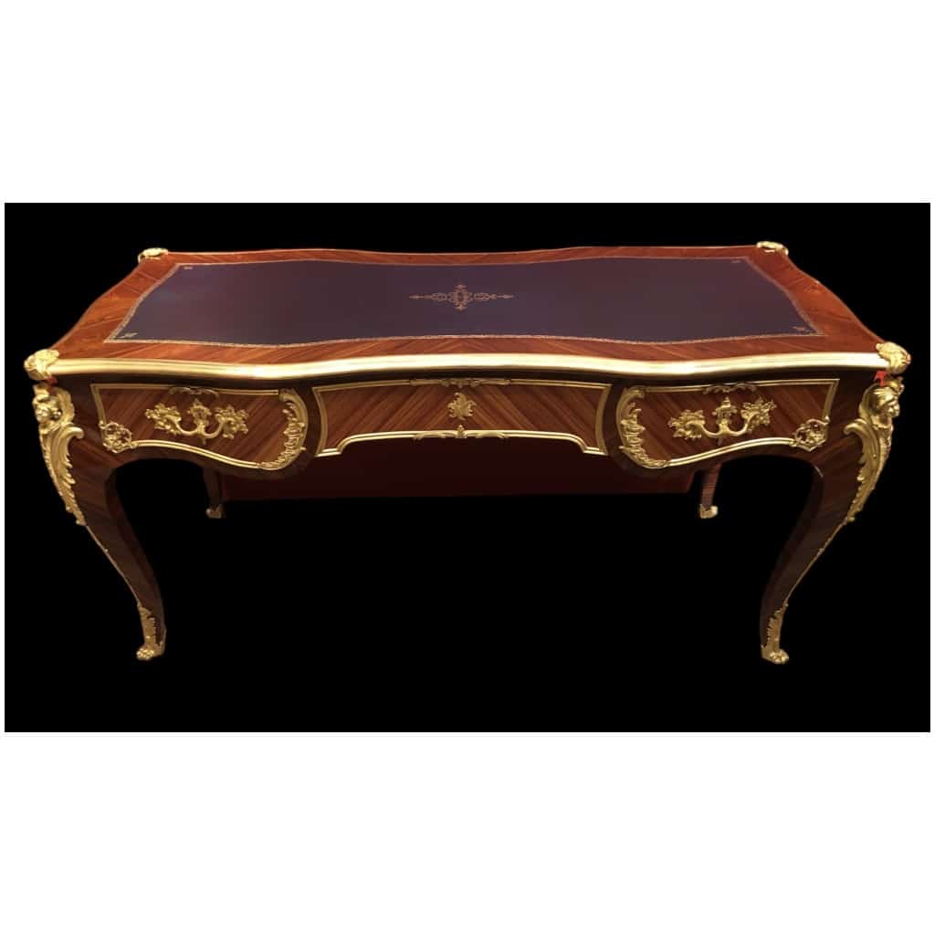 Louis XV style flat desk in rosewood and violet wood veneer, opening with three belt drawers and resting on arched legs. 17