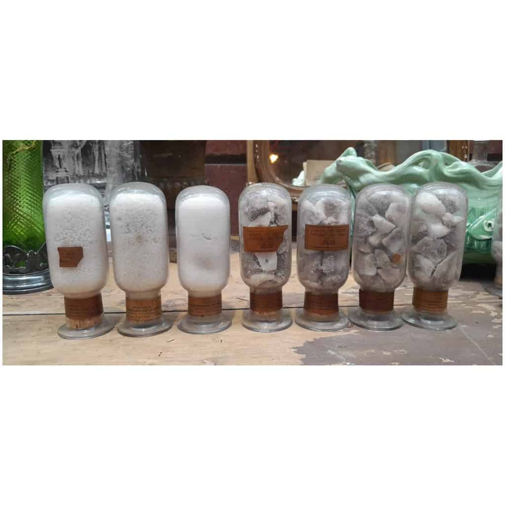 Collection of 7 inverted bottles containing different states of natural sodium nitrate from Chile 3