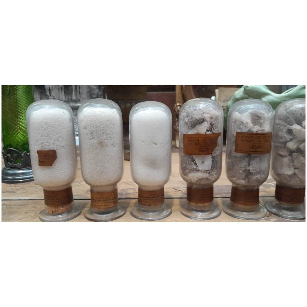 Collection of 7 inverted bottles containing different states of natural sodium nitrate from Chile 6