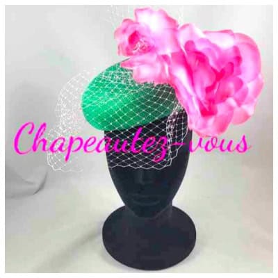 Green sisal fascinator decorated with shaded pink flowers and a pale pink veil
