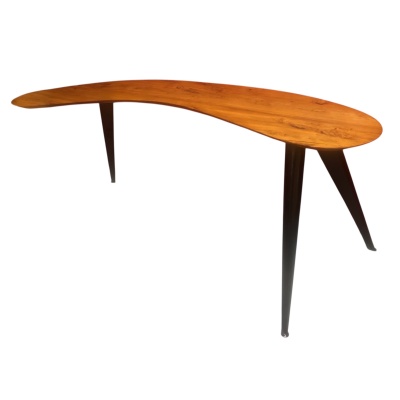 Bureau Boomerang de style design en bois fruitier reposant sur trois pieds en métal.